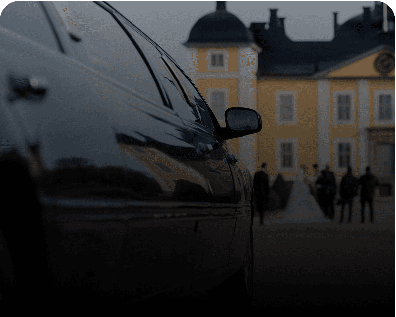 Limousine parked in front of elegant mansion.